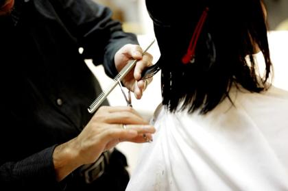 Estilista cortando el cabello de una clienta en el salón